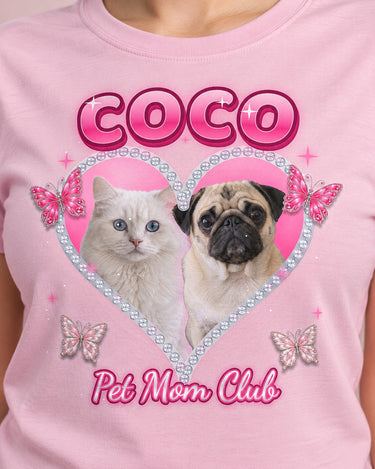 Close-up of the rhinestone heart print on a light pink t-shirt: a pug and a white cat, glittery butterflies, bubble letters and silver script